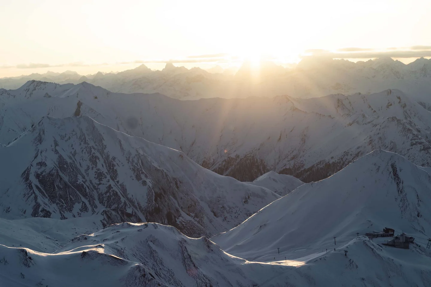 Ferienglück und Alpenland | Ihre stilvollen Hotels in Ischgl Verschneite Berglandschaft im Abendlicht mit weitläufigem Alpenpanorama