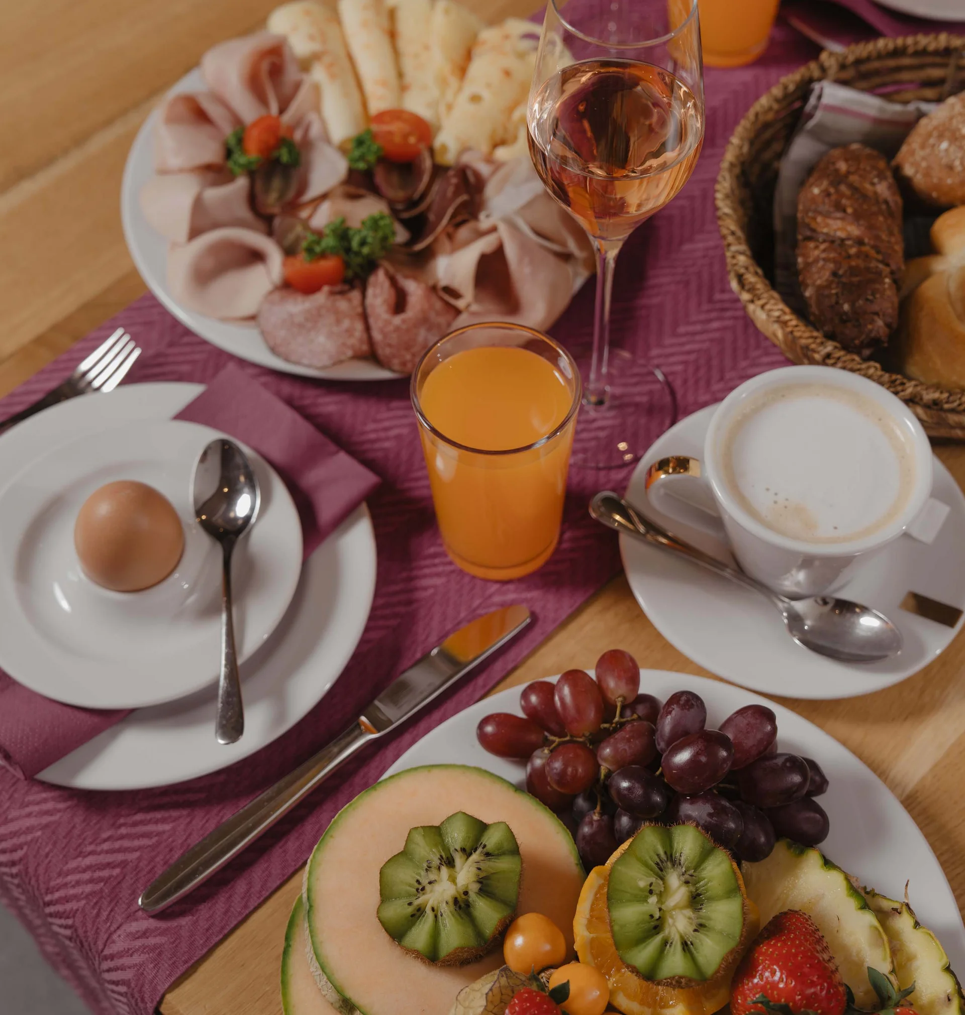 Ferienglück und Alpenland | Ihre stilvollen Hotels in Ischgl Frühstückstisch mit Aufschnitt, Brot, Obst, Eiern, Saft und Kaffee