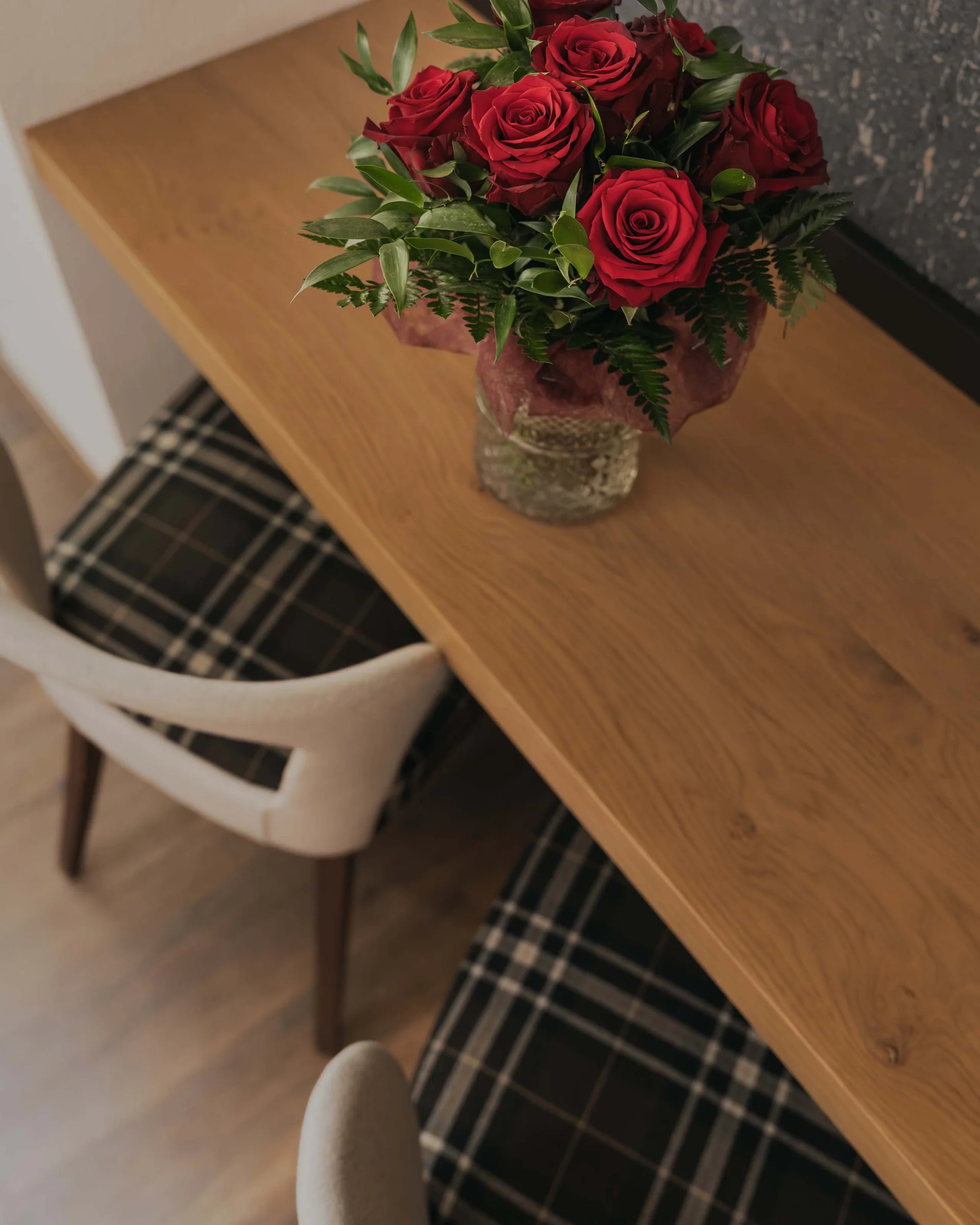 Ferienglück und Alpenland | Ihre stilvollen Hotels in Ischgl Bouquet aus roten Rosen in einer Vase auf einem Holztisch