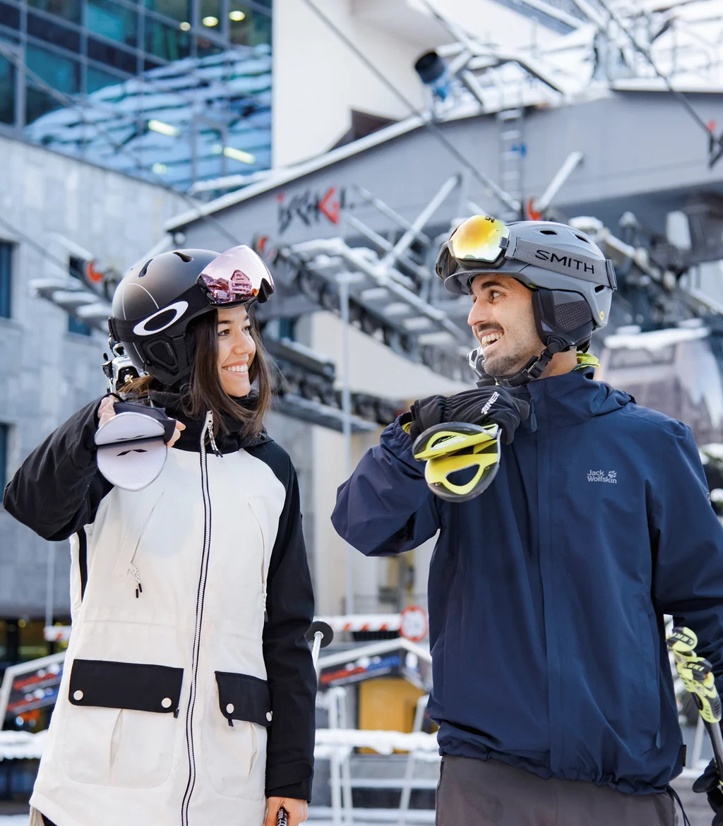 Ferienglück und Alpenland | Ihre stilvollen Hotels in Ischgl Zwei Wintersportler mit Helmen vor einem verschneiten Skilift